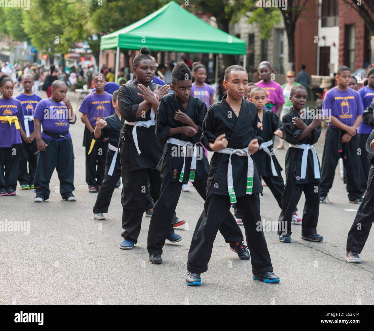 Grupo afroamericano da una demostración de artes marciales en Harlem en Nueva York durante una feria de la calle Foto de stock