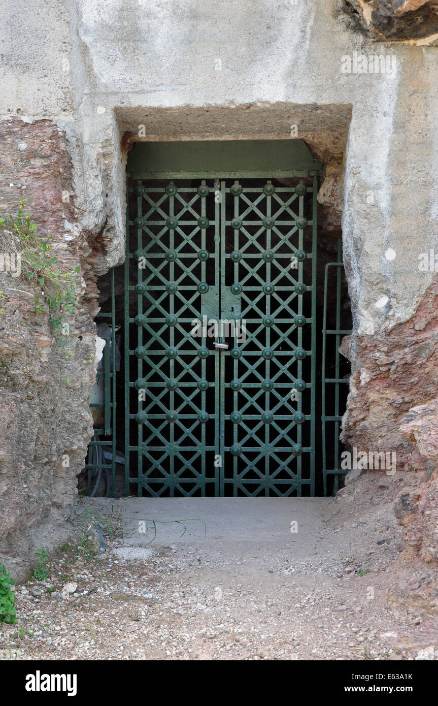 Fuente de pnyx cisterna antigua puerta de hierro cerrada cortados en la roca exterior. Atenas, Grecia. Foto de stock