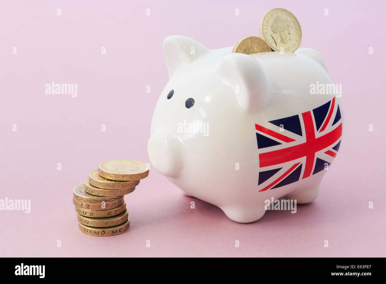 British Union Jack en la hucha mirando un montón de libras esterlinas libra monedas ilustrando el ahorro y el crecimiento financiero concepto. Reino Unido de Gran Bretaña Foto de stock