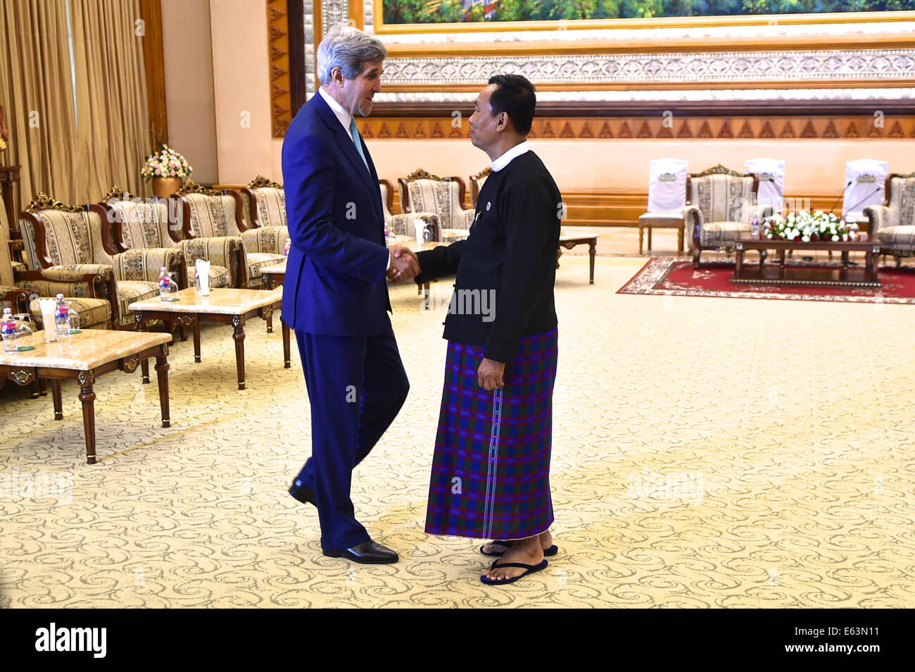 El portavoz de la Cámara Baja del Parlamento birmano Shwe Mann prepara a saludar a la Secretaria de Estado de los Estados Unidos John Kerry como él llega al edificio del Parlamento en Naypyitaw, Myanmar (Birmania), el 9 de agosto, 2014, para una discusión bilateral anterior a una reunión de la ASEAN. Foto de stock