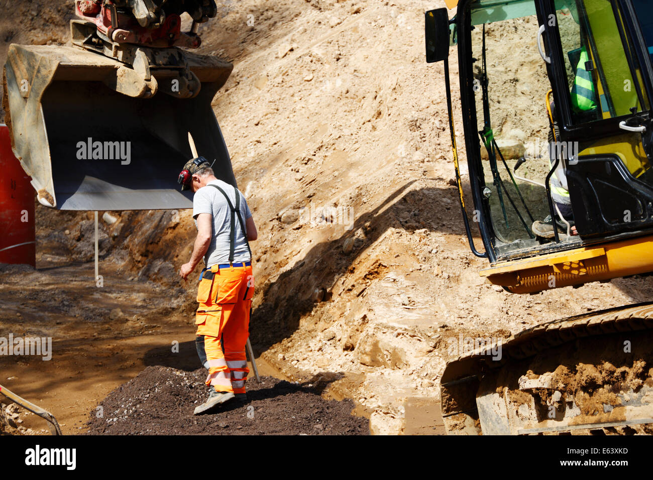 Trabajador de construcción y una topadora en obras de excavación, close-ups Foto de stock