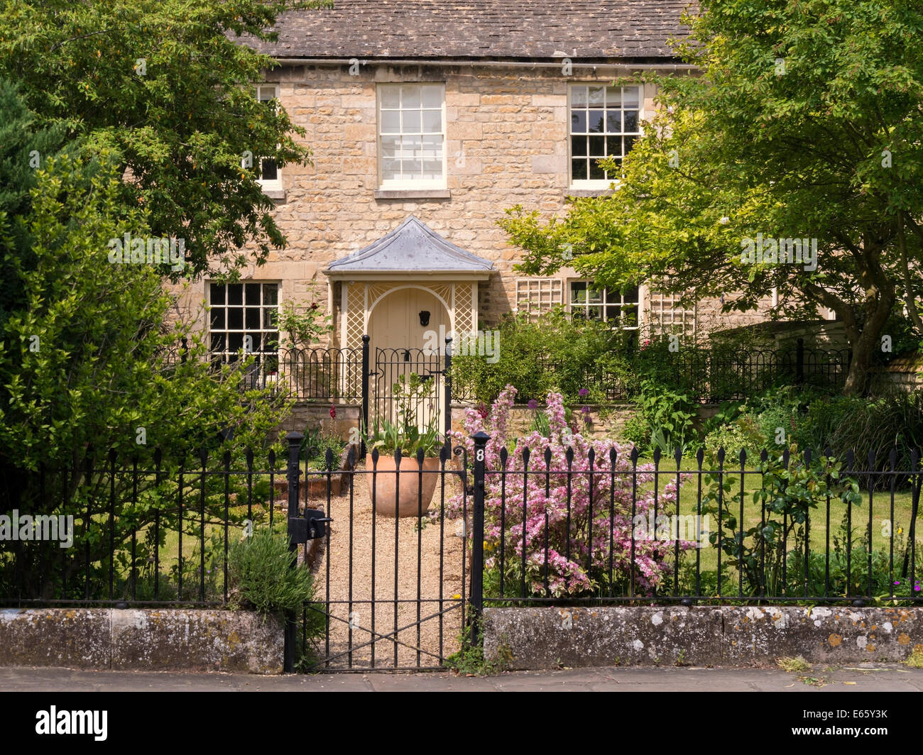 Atractivo viejo stone town house cottage con bonito porche, jardín y rejas metálicas, baño fila,Stamford, Lincolnshire, Inglaterra, Reino Unido Foto de stock