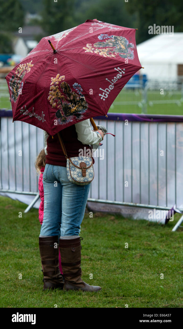 Mujer se situó bajo un paraguas Thelwell en Perth Show 2014. Foto de stock