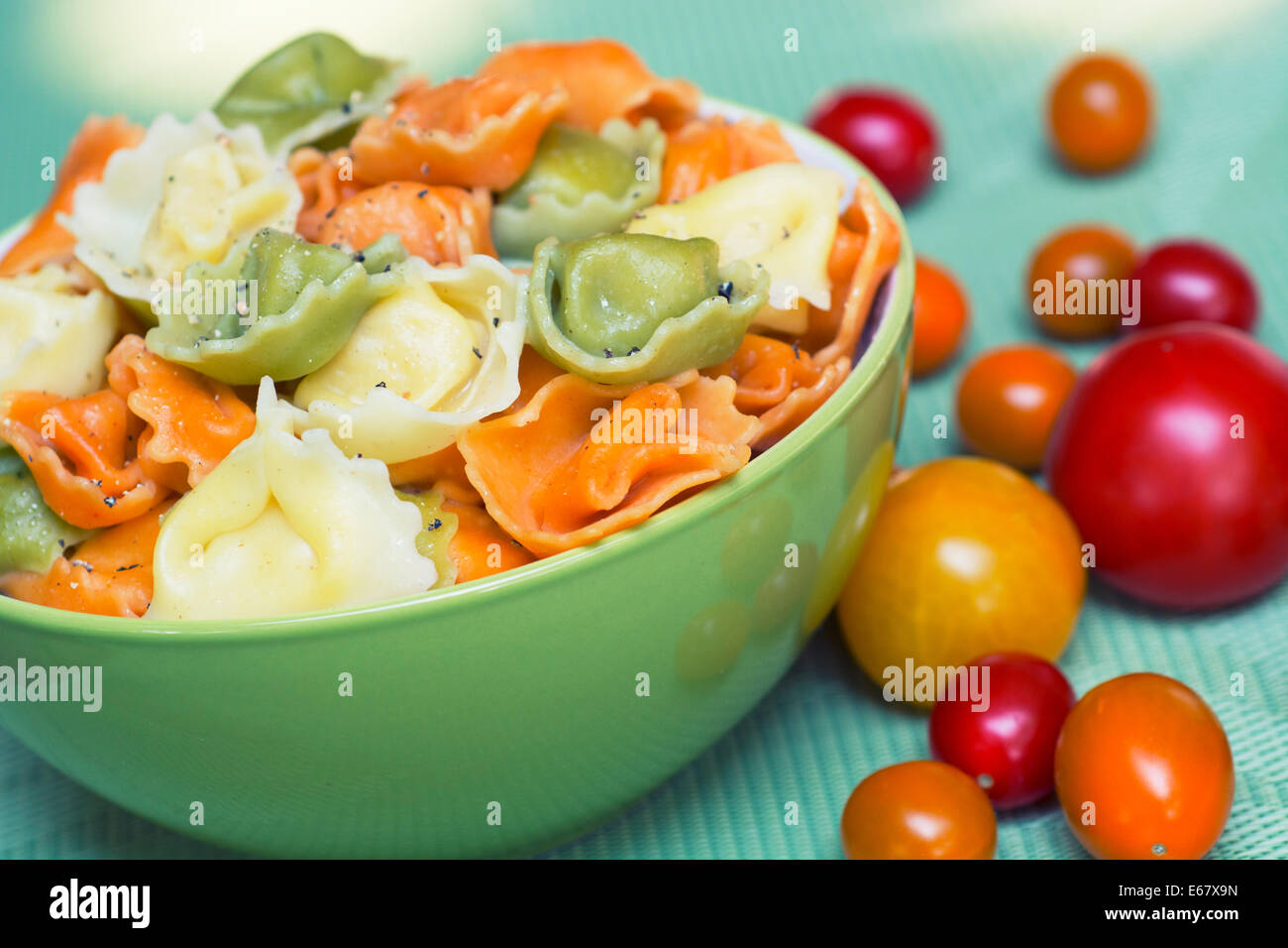 Tortellini, tricolor, Verde Pasta de color naranja en un tazón Foto de stock