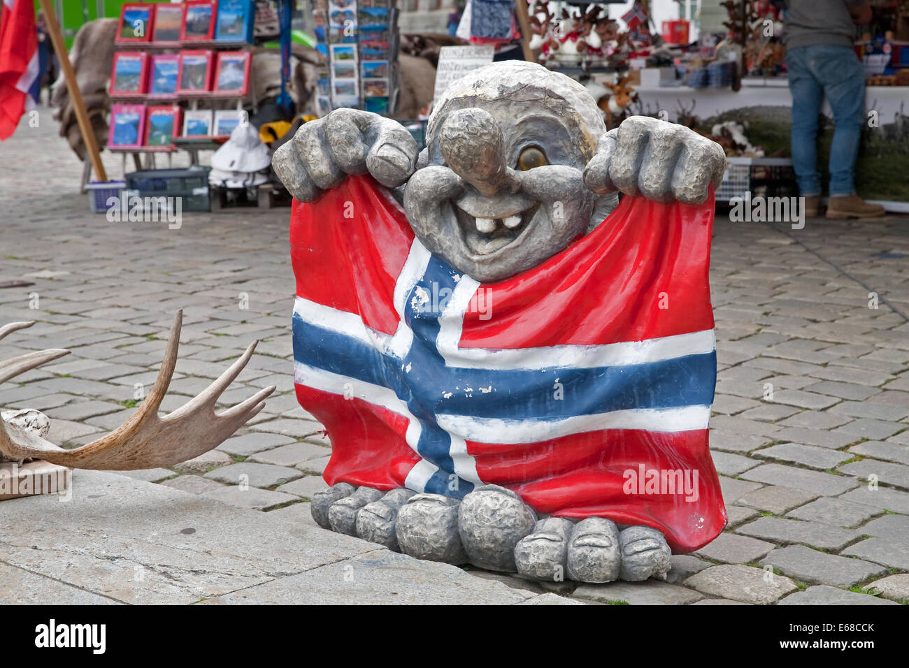 Una estatua de un troll sosteniendo la bandera noruega fuera de una tienda de souvenirs en Bergen, Noruega Foto de stock