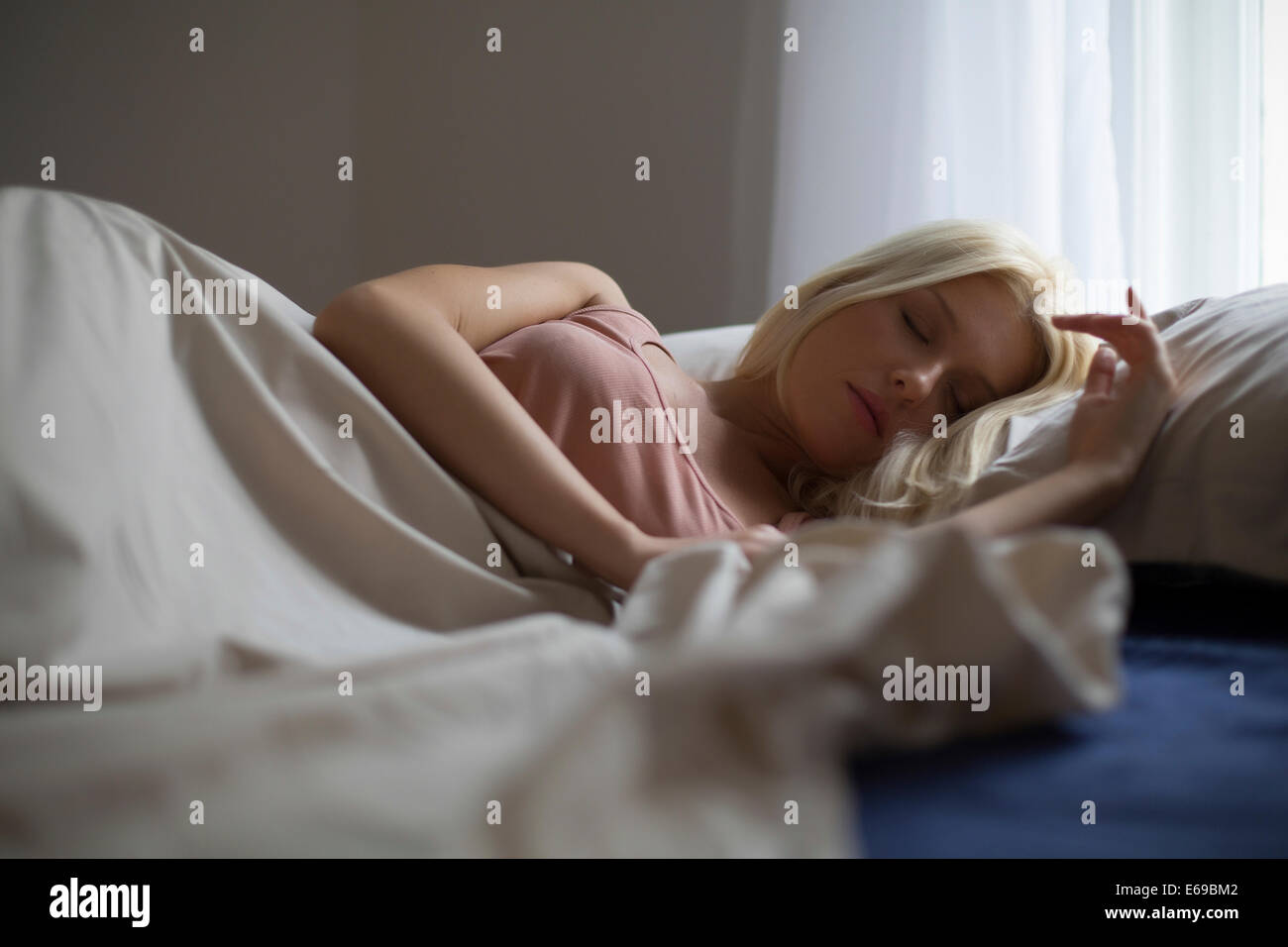 Mujer caucásica durmiendo en cama Foto de stock