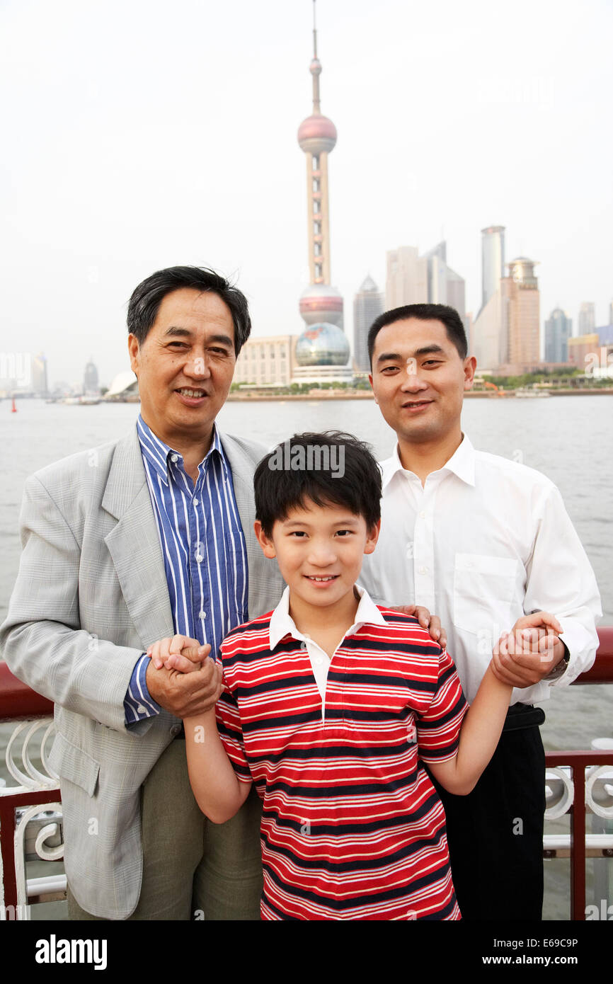 Tres generaciones de hombres sonrientes por el horizonte de la ciudad de Shanghai, China Foto de stock