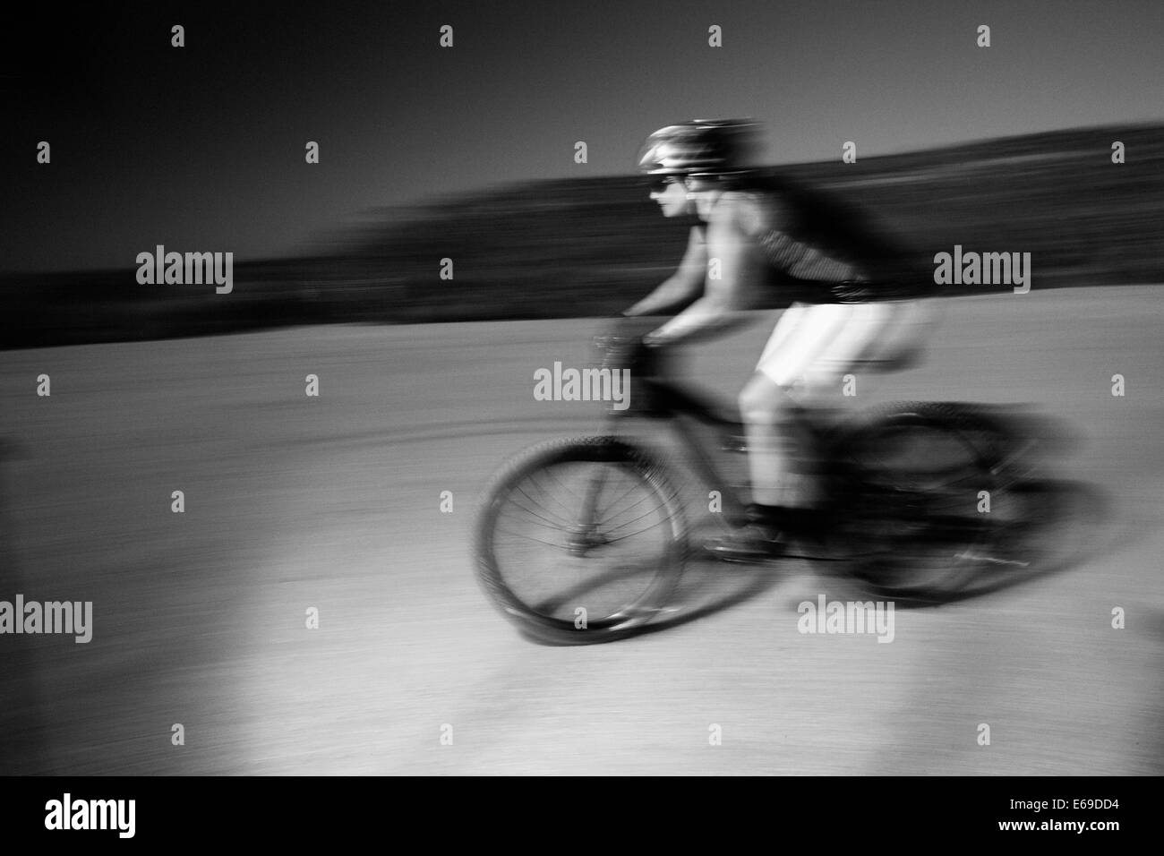 Mujer montando en bicicleta de montaña en el desierto Foto de stock