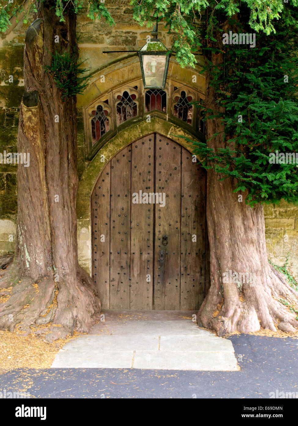 St Edward's Parroquia norte puerta flanqueada por árboles de tejo, Stow-on-the-Wold, Gloucestershire, Reino Unido Foto de stock