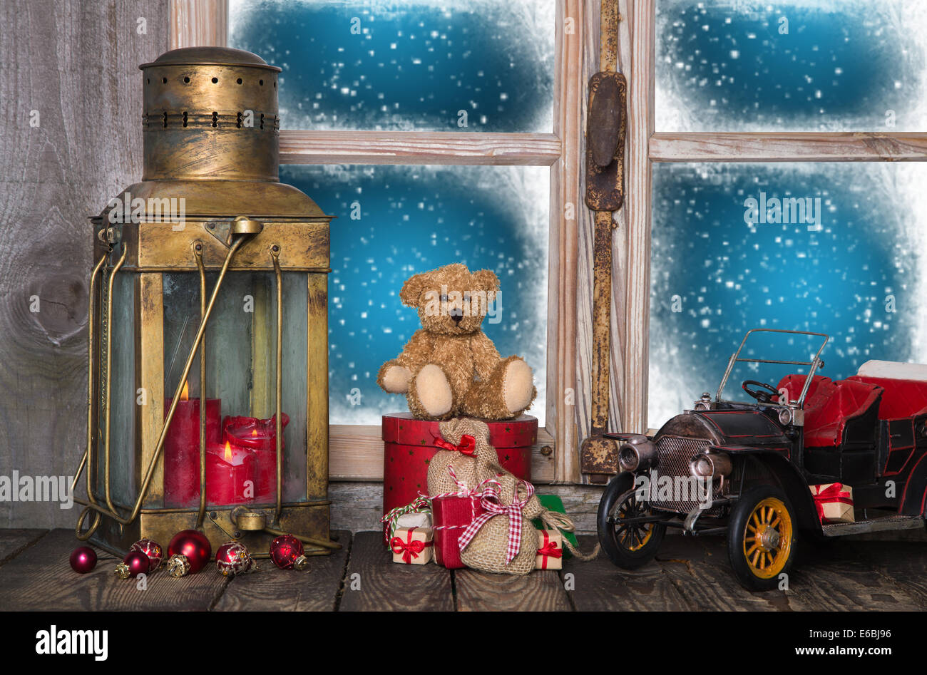 Antiguas decoraciones navideñas en el alféizar de la ventana de madera con vintage nostálgico y juguetes. Foto de stock