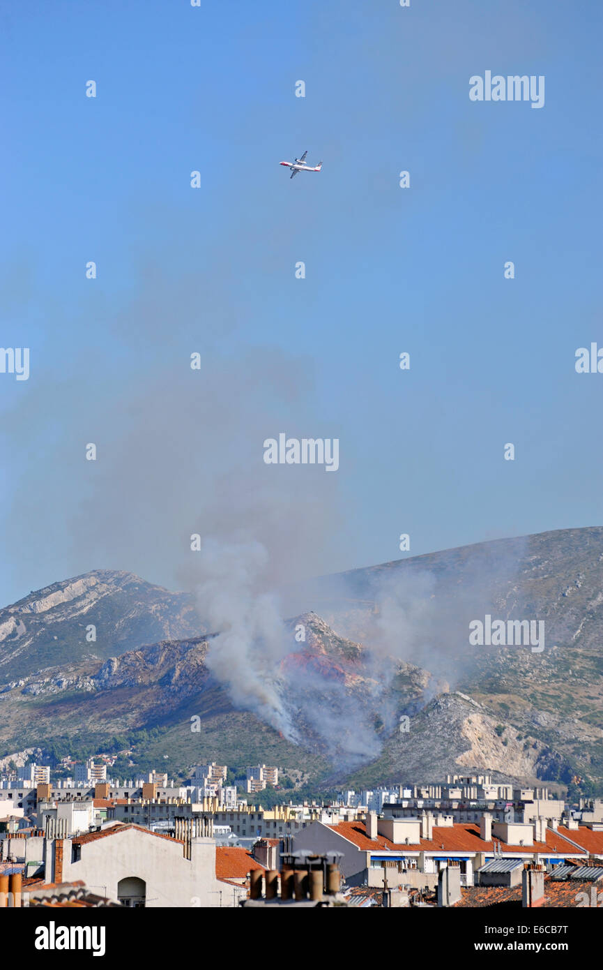 Avión dejando un incendio forestal, tras caer retardante de fuego, Marsella, Francia, Europa en temporada alta Foto de stock