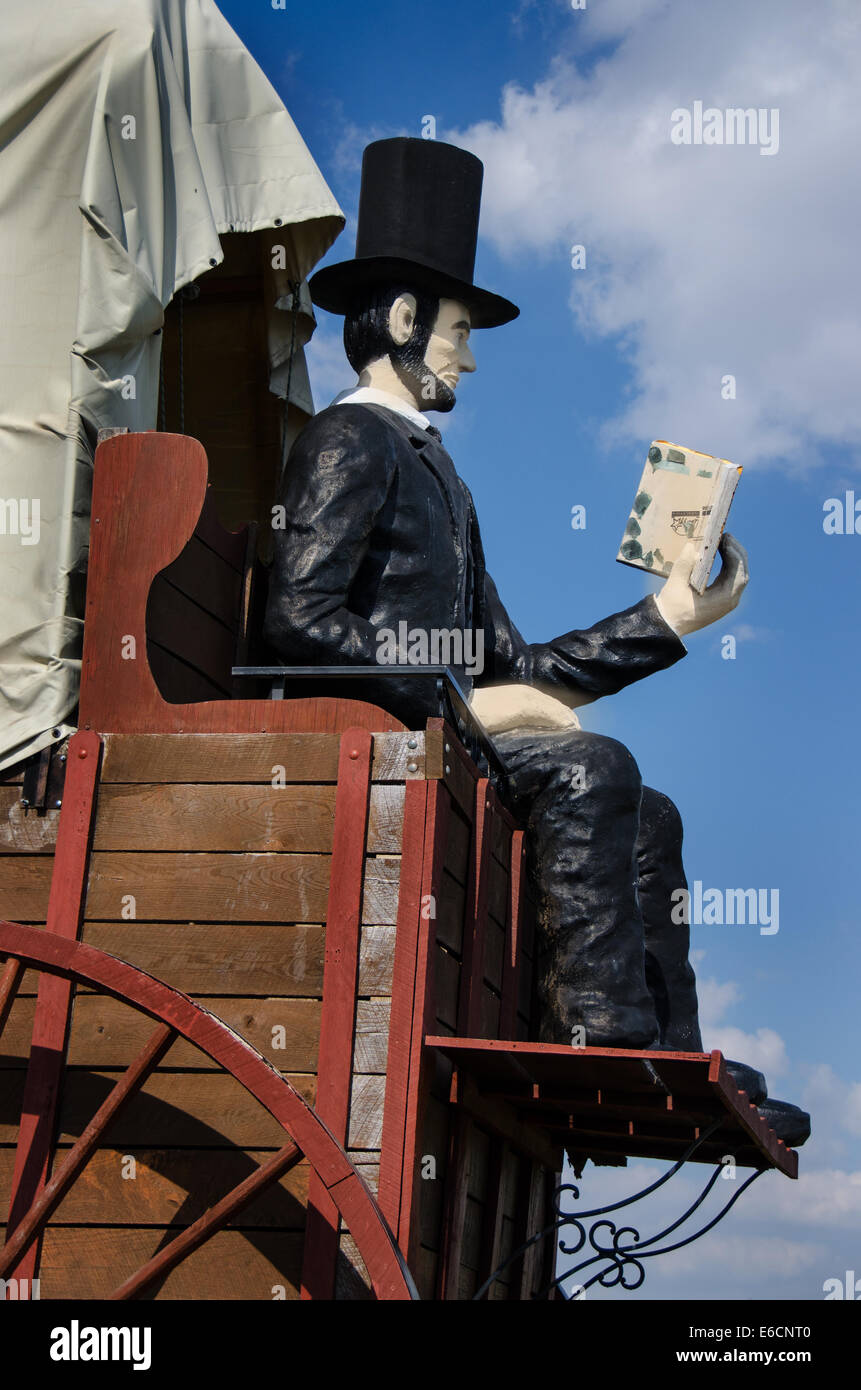 Los Railsplitter Covered Wagon dispone de Abraham Lincoln sentado en un vagón cubierto leyendo un libro. Foto de stock