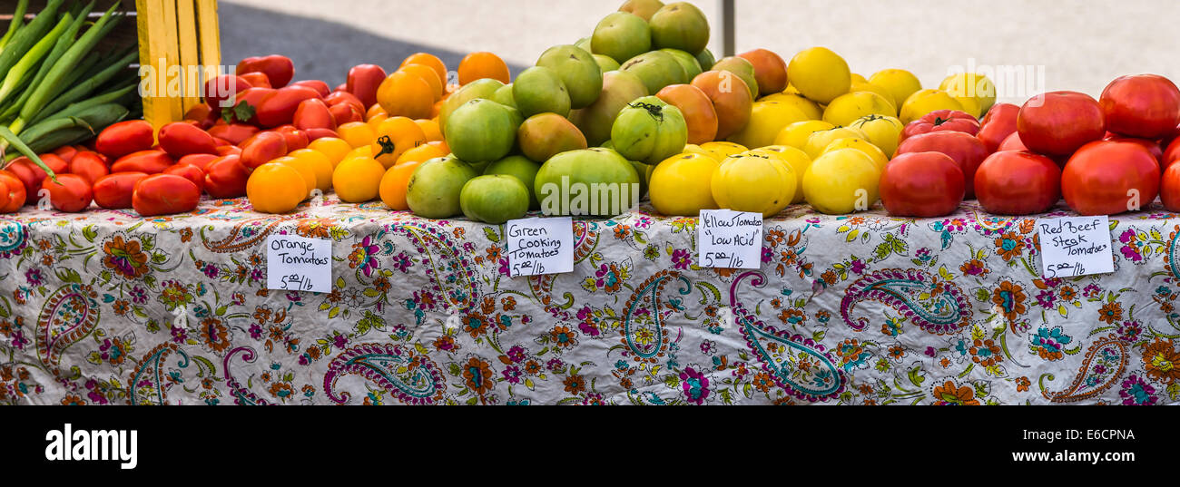 Tomates para la venta en un mercado de granjeros. Foto de stock