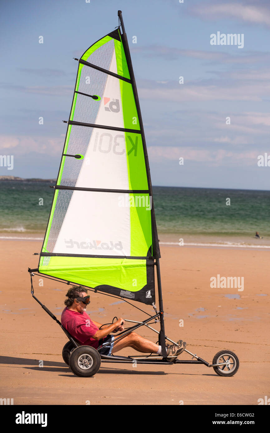 Un hombre en un yate de arena en la playa de Bamburgh en Northumberland, Reino Unido. Foto de stock