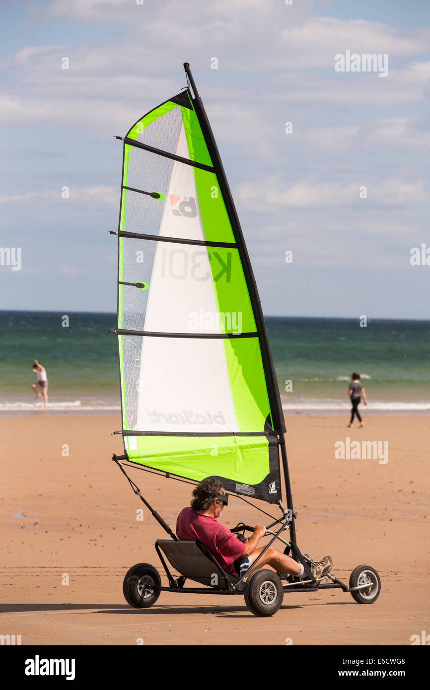 Un hombre en un yate de arena en la playa de Bamburgh en Northumberland, Reino Unido. Foto de stock