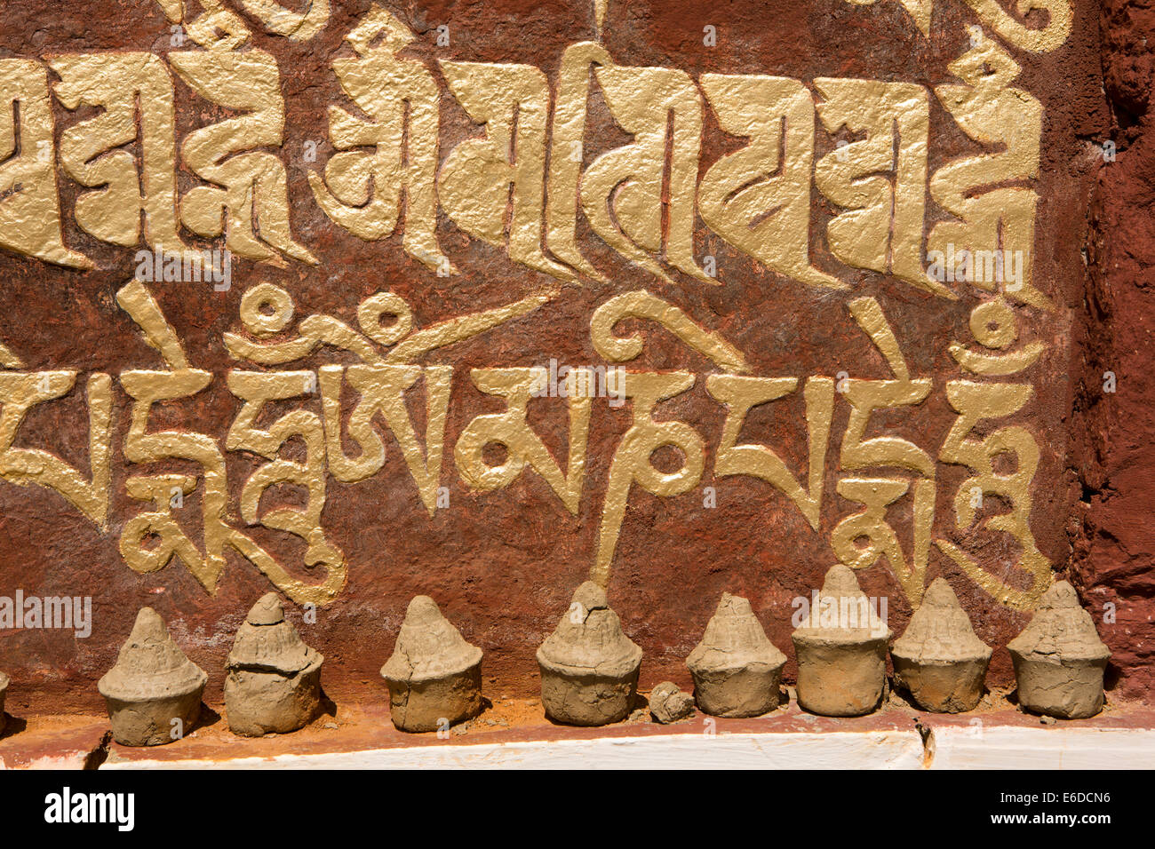 Bhután oriental, Mongar, Yadi village, arcilla diminutas chortens budistas junto a mani mantra de pared Foto de stock