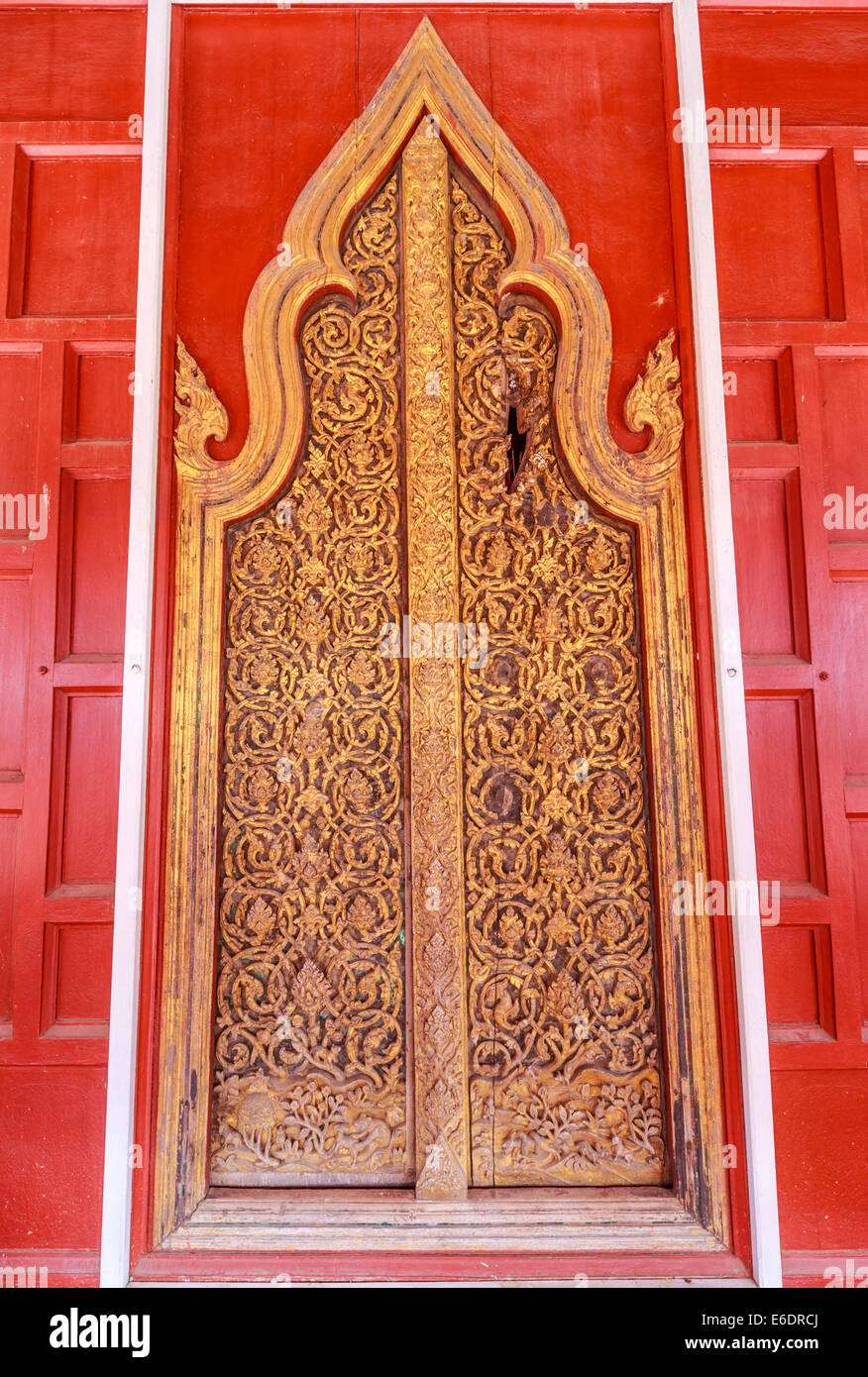 Esta puerta antigua se encuentra en Wat Yai Suwannaram en Petchburi, Tailandia. Los daños en la parte superior derecha de la puerta estaba hacha Foto de stock