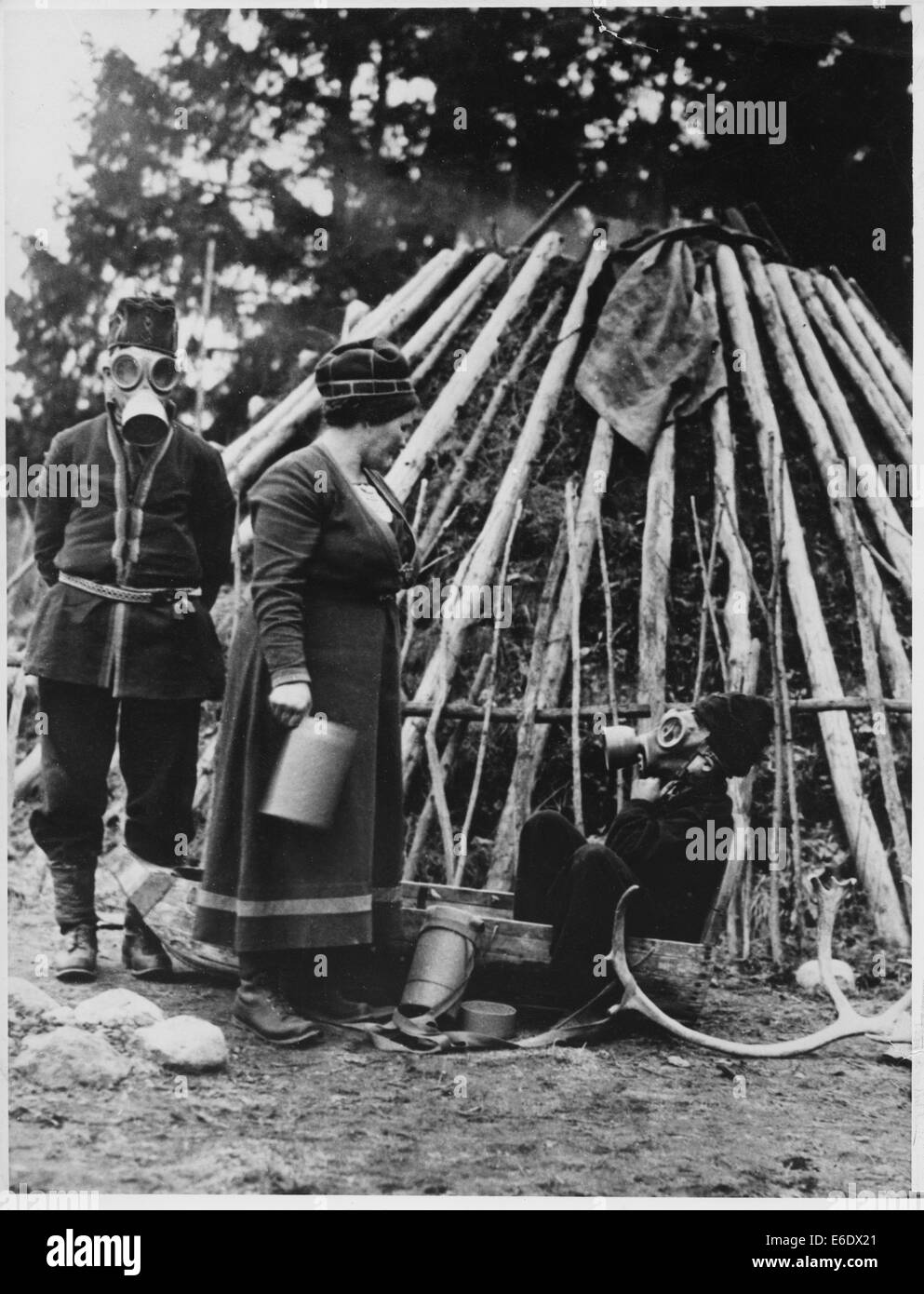 Familia lapona con máscaras de gas autorizados para la protección del aire delante de sus primitivos que habitan en preparación de la guerra, Suecia Foto de stock