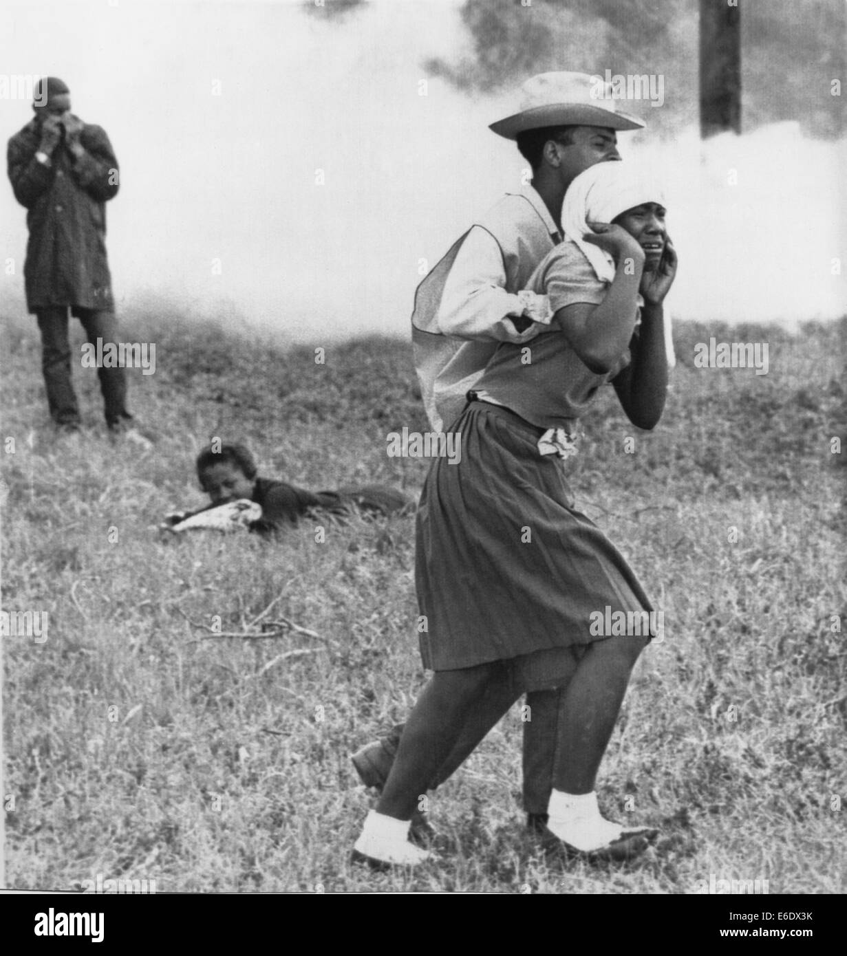 Demostrador de Derechos Civiles ayudando joven después de que la policía lanzando bombas de humo, Camden, Alabama, Estados Unidos, 1965 Foto de stock