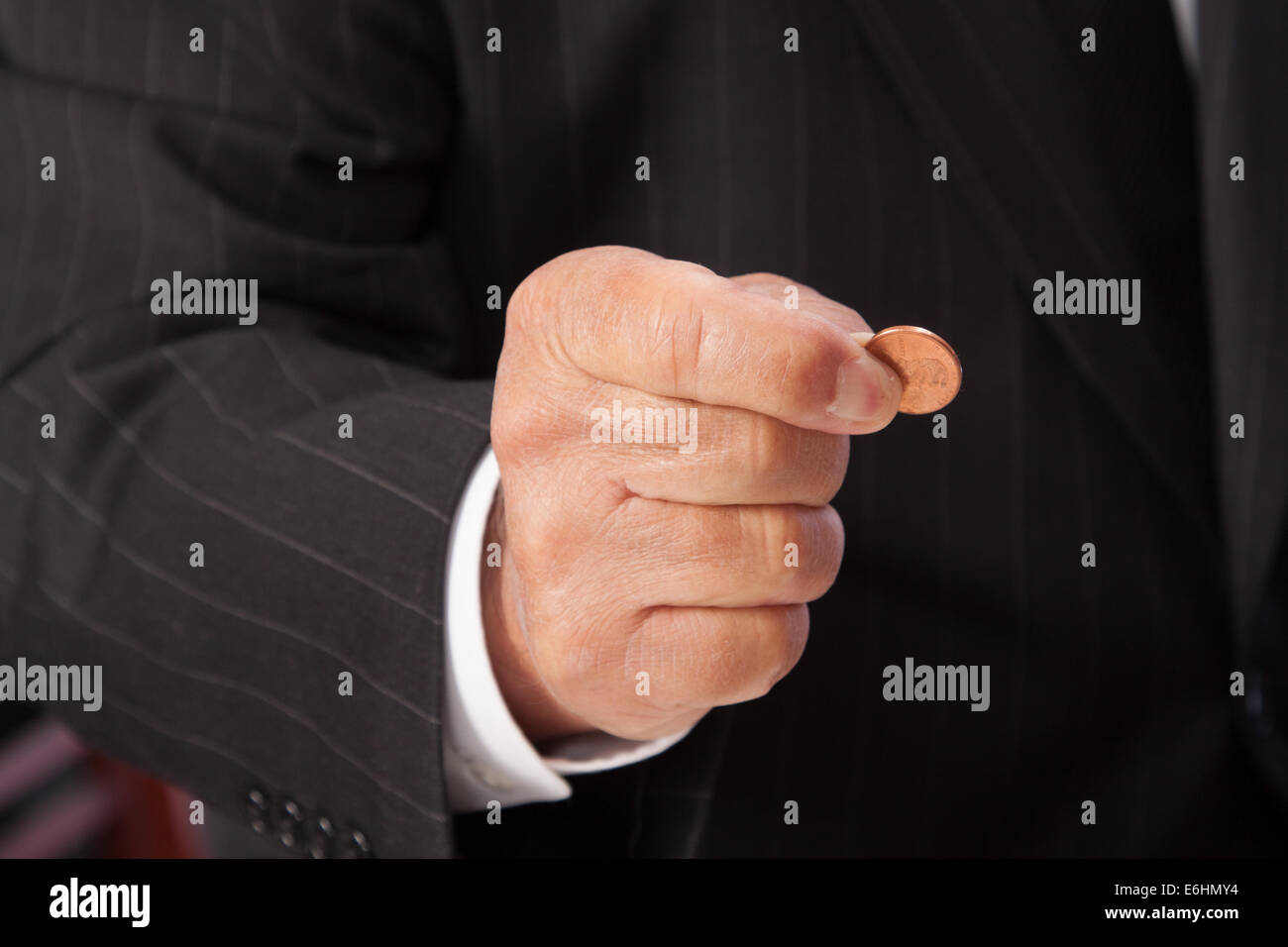 La mano del hombre pellizcando pennyhorizontal, vestido con traje de