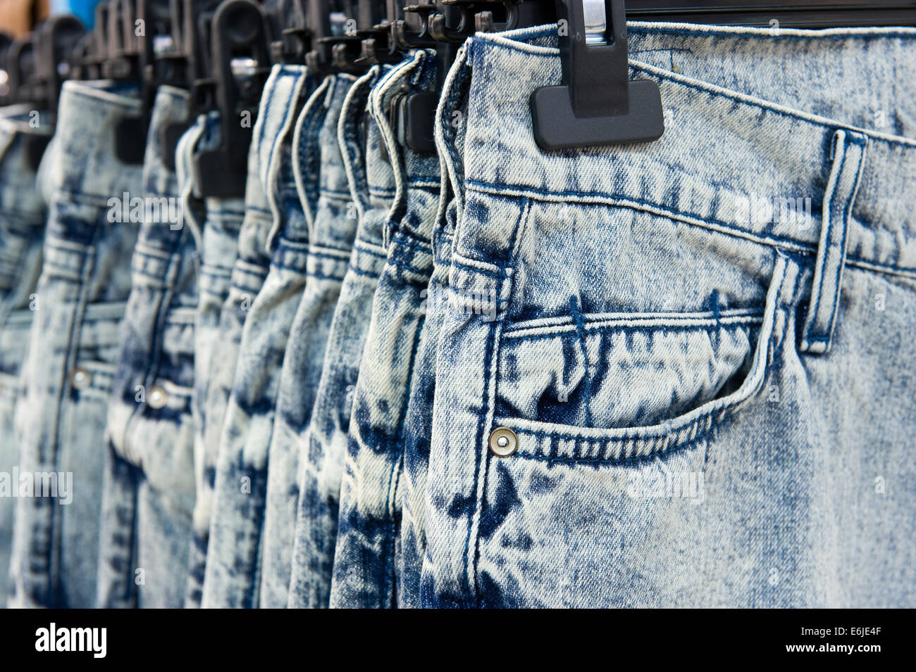 Nuevos blue jeans colgados en una tienda Foto de stock