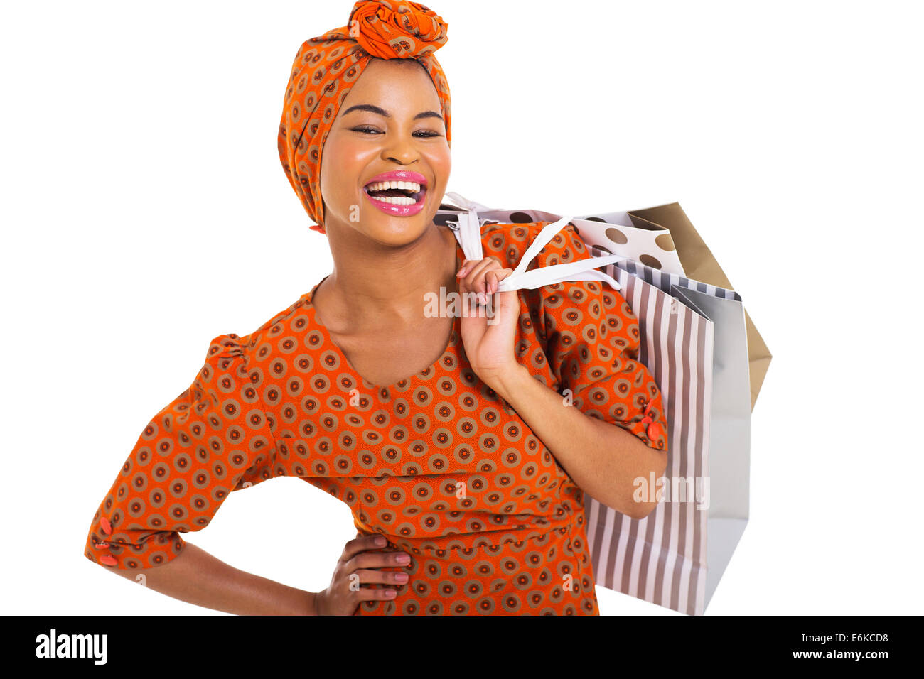 Feliz mujer negra llevando bolsas de compras sobre fondo blanco. Foto de stock