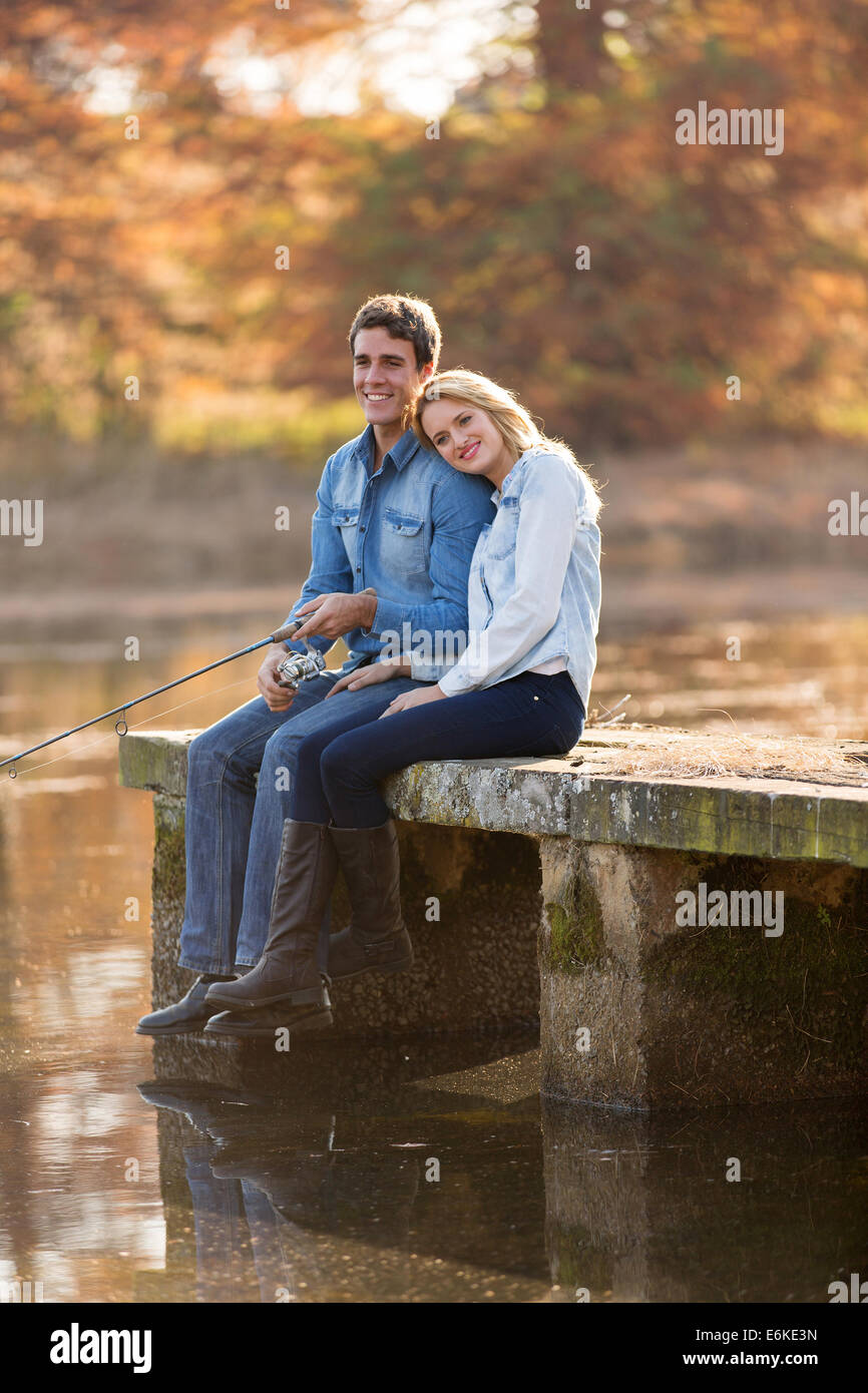 Feliz joven y su novia en el muelle de pesca Foto de stock