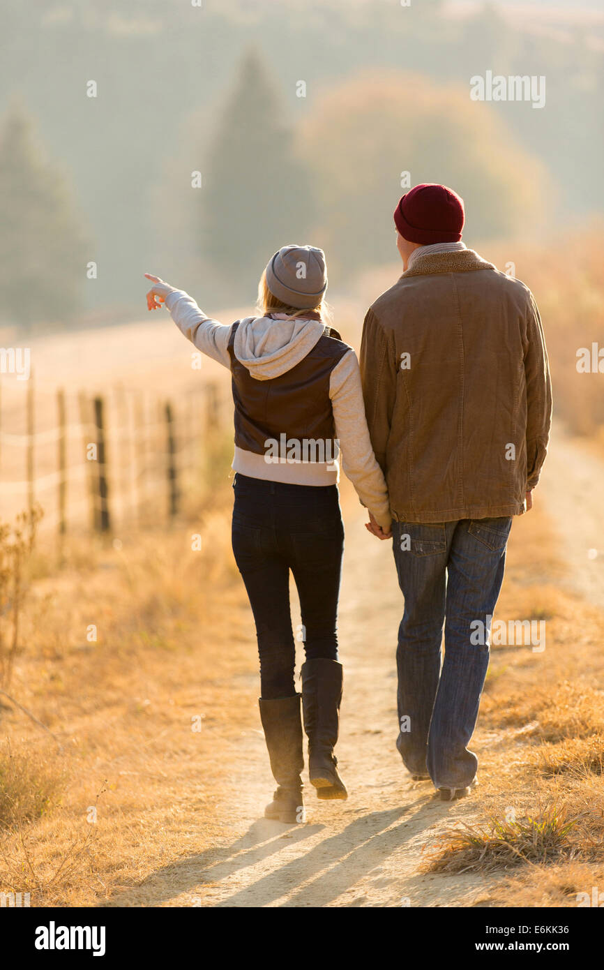 Vista trasera de la joven pareja caminando en Country Road Foto de stock