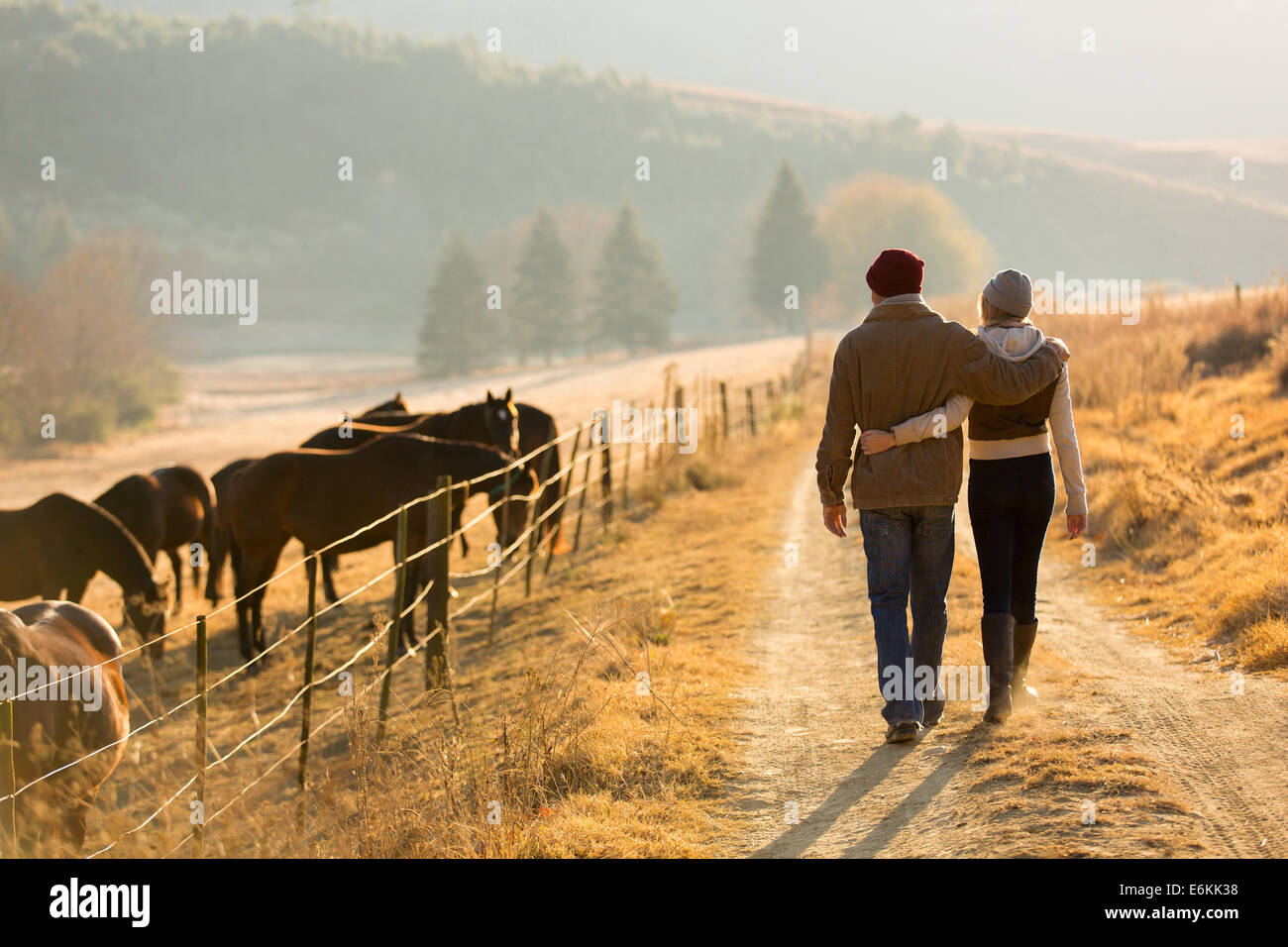 Vista posterior de la joven pareja caminando en Farm Road Foto de stock