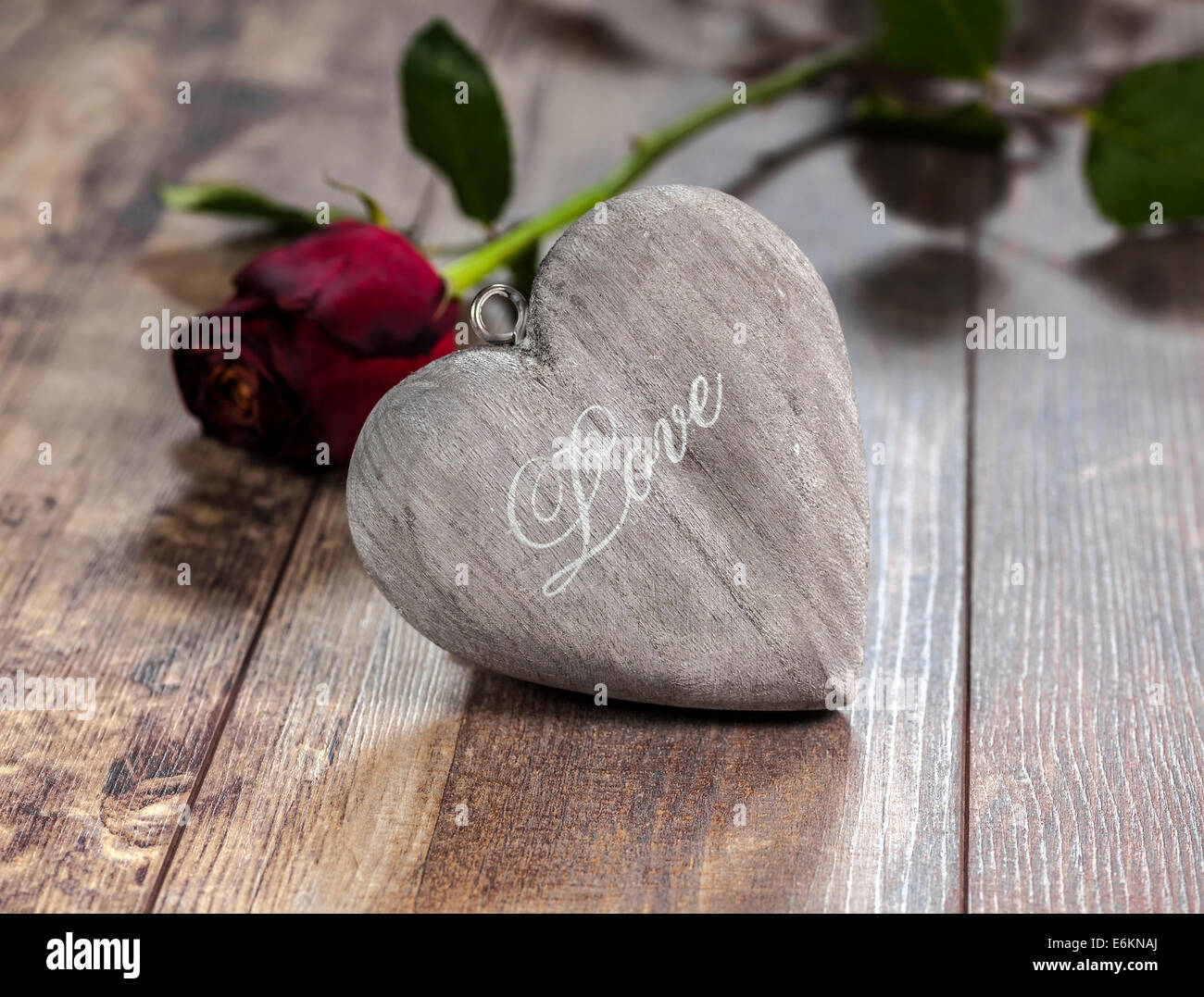Símbolo del día de San Valentín. Corazón sobre un fondo de madera con rosa roja. Foto de stock