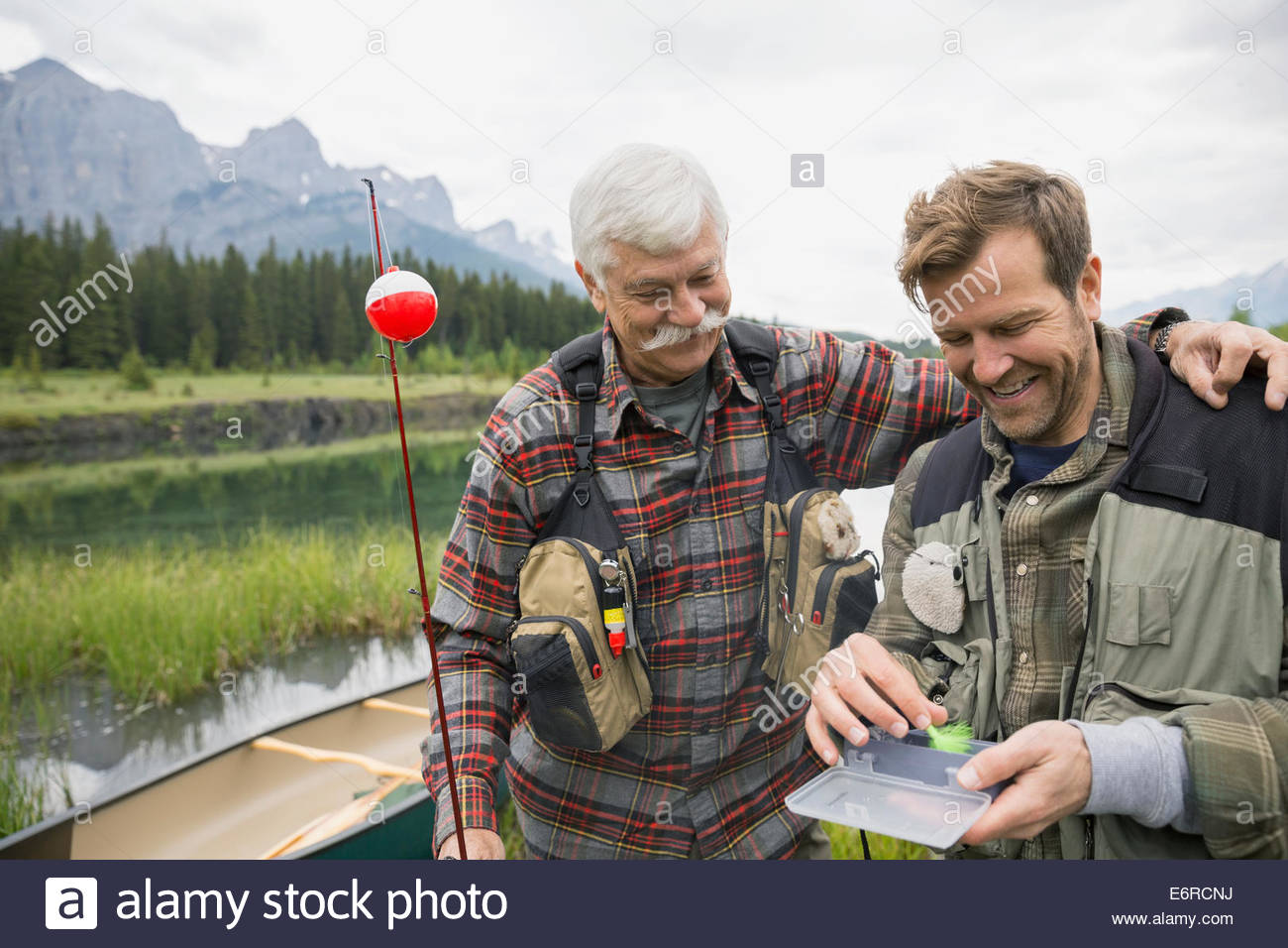 Padre e hijo examinar aparejos de pesca Foto de stock