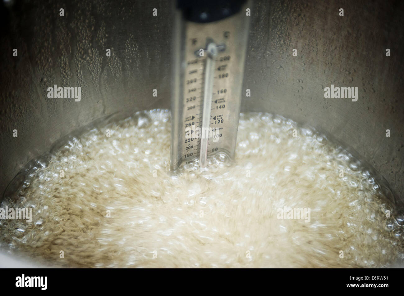 (140830) -- BEIJING, 30 de agosto del 2014 (Xinhua) -- Foto tomada el 29 de agosto de 2014 muestra la malta jarabe hirviendo en la cocina de Yoo caramelos en Beijing, capital de China. Como chef de la Candy Candy Yoo, una confitería en Beijing, Chen Jingchao Nanluoguxiang's job es convertir dulces artesanales frescos junto con sus aprendices. Antiguamente un profesional de TI en China oriental de Shanghai, los 24 años de edad joven comenzó a aprender candymaking en 2013 y decidió proseguir su carrera en Beijing en mayo. Yoo Candy del golpe del producto es la "roca" de Australia, un cilíndrico Hard Candy con telas diseño en su t Foto de stock