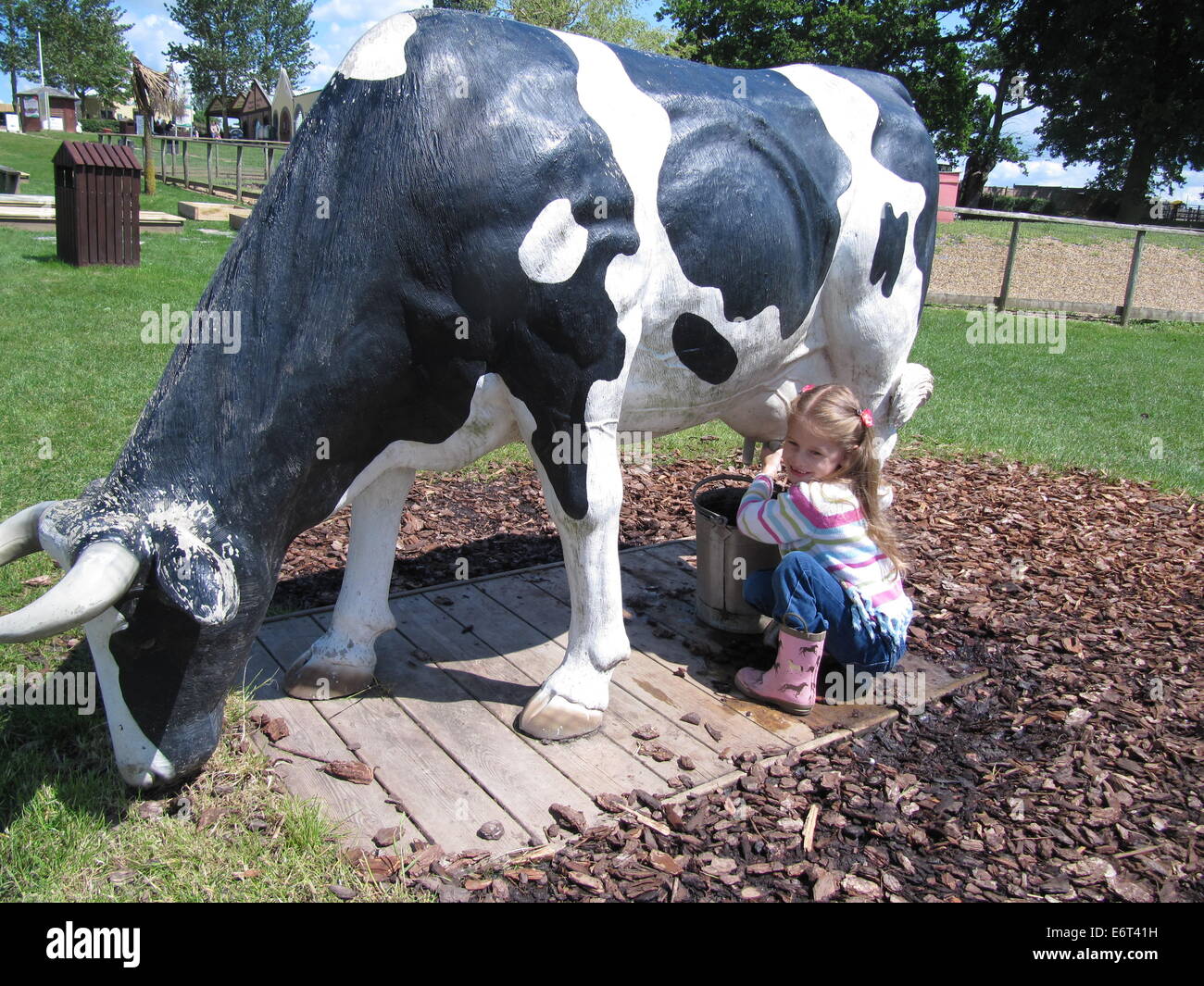 Chica ordeñando una vaca Foto de stock