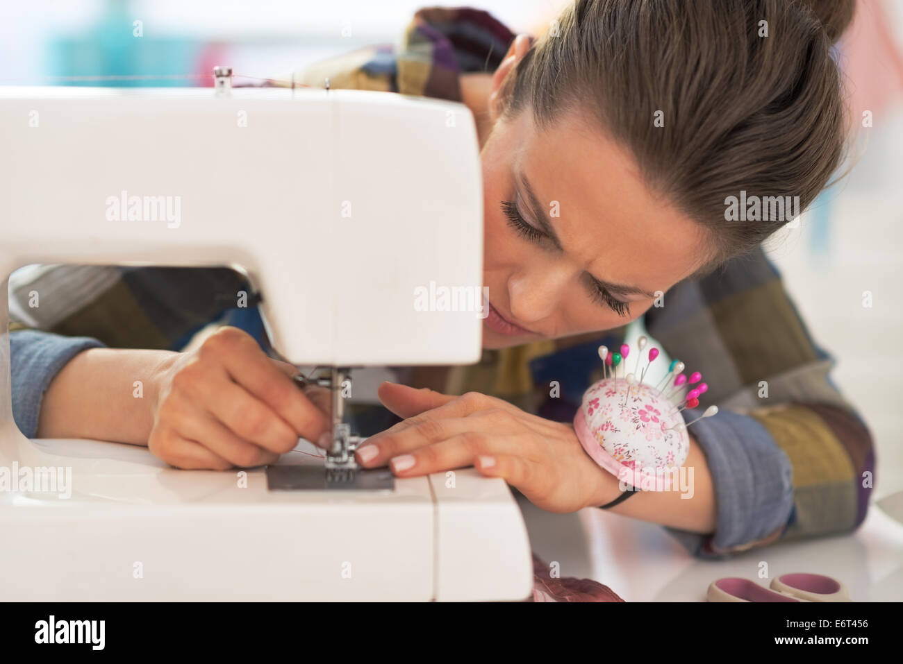Modista mujer trabajando con máquina de coser Foto de stock