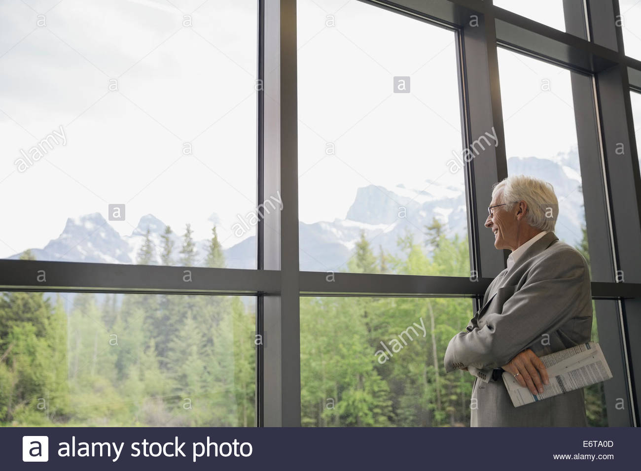 Empresario admirando el paisaje desde la ventana Foto de stock