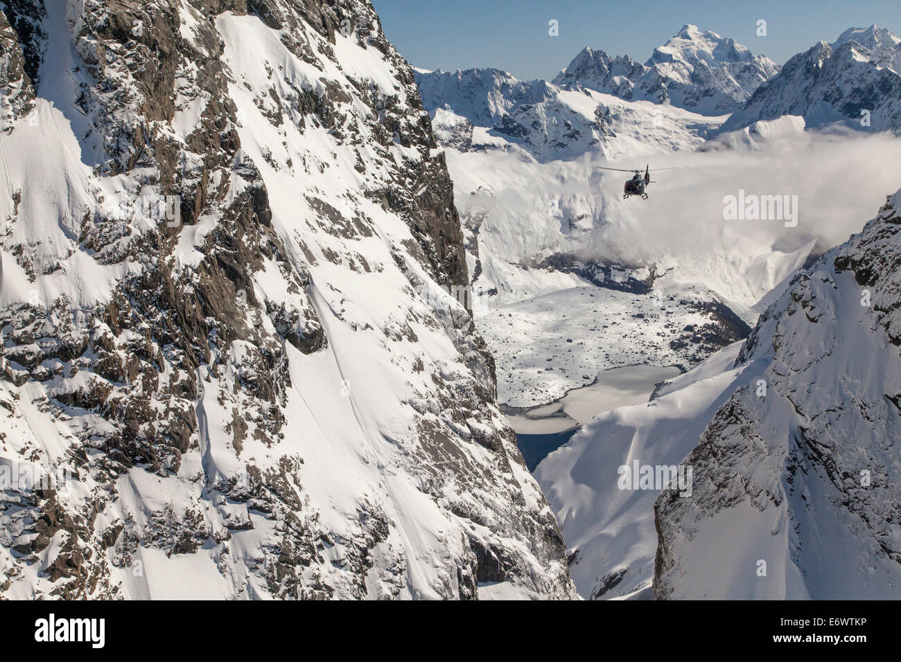 Vuelo en helicóptero a través de un barranco en montañas nevadas, Alpes del Sur, Isla del Sur, Nueva Zelanda Foto de stock
