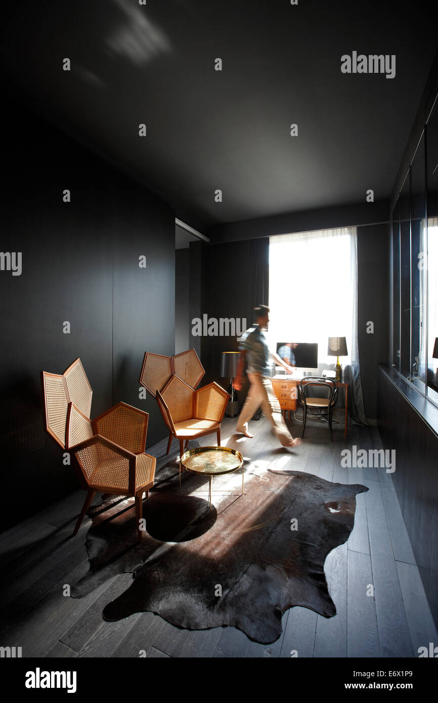 El hombre pasa un salón en una habitación de hotel, Paris, Francia Foto de stock