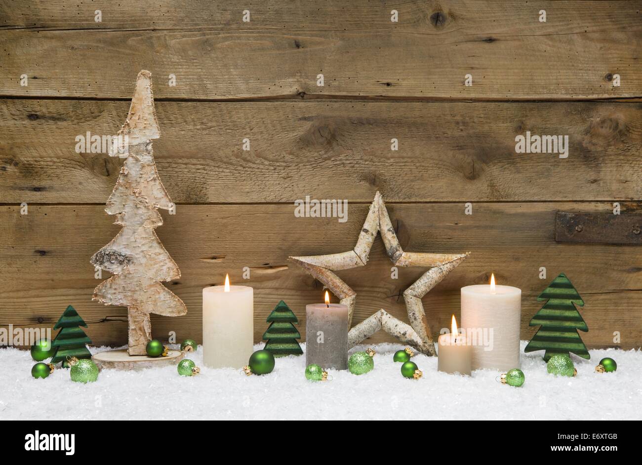 Cuatro velas blancas sobre un viejo fondo de madera. Decoraciones navideñas  atmosféricas con calendario de adviento hecho a sí mismo y elementos  naturales consistentes. Salvado Fotografía de stock - Alamy