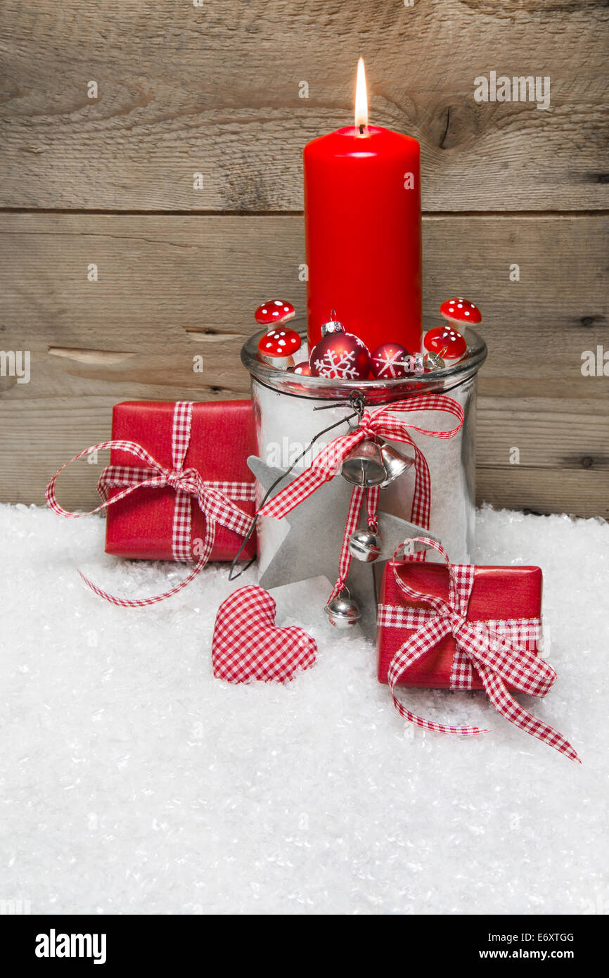 Tarjeta de navidad con velas rojas, presenta marcada en rojo y blanco y  decoración, nieve sobre fondo de madera Fotografía de stock - Alamy