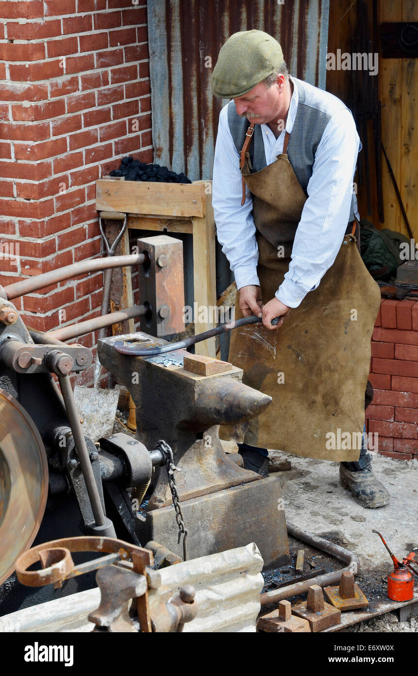 Herrero demostrar el uso de un martillo de forja mecánico para forjar  pequeños elementos metálicos Fotografía de stock - Alamy