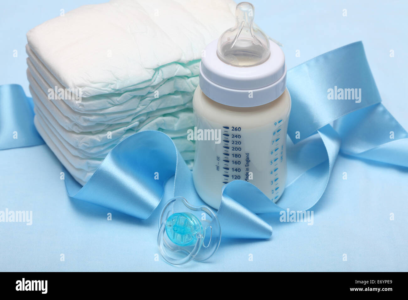 Biberón con leche, pañales, chupete, y blue ribbon. Closeup Fotografía de  stock - Alamy