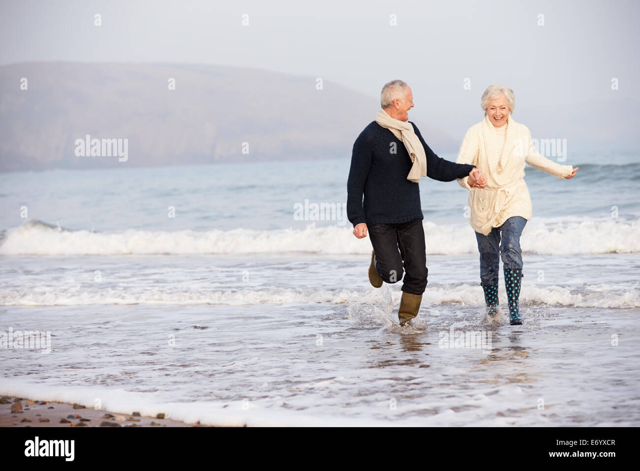 Par superior funcionando a lo largo de la playa de invierno Foto de stock