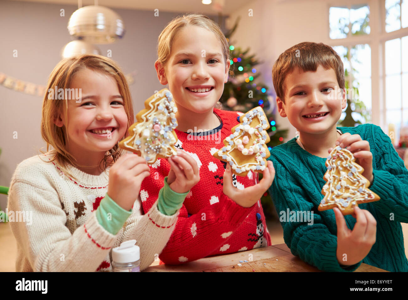 Tres niños mostrando decoradas Galletas de Navidad Foto de stock