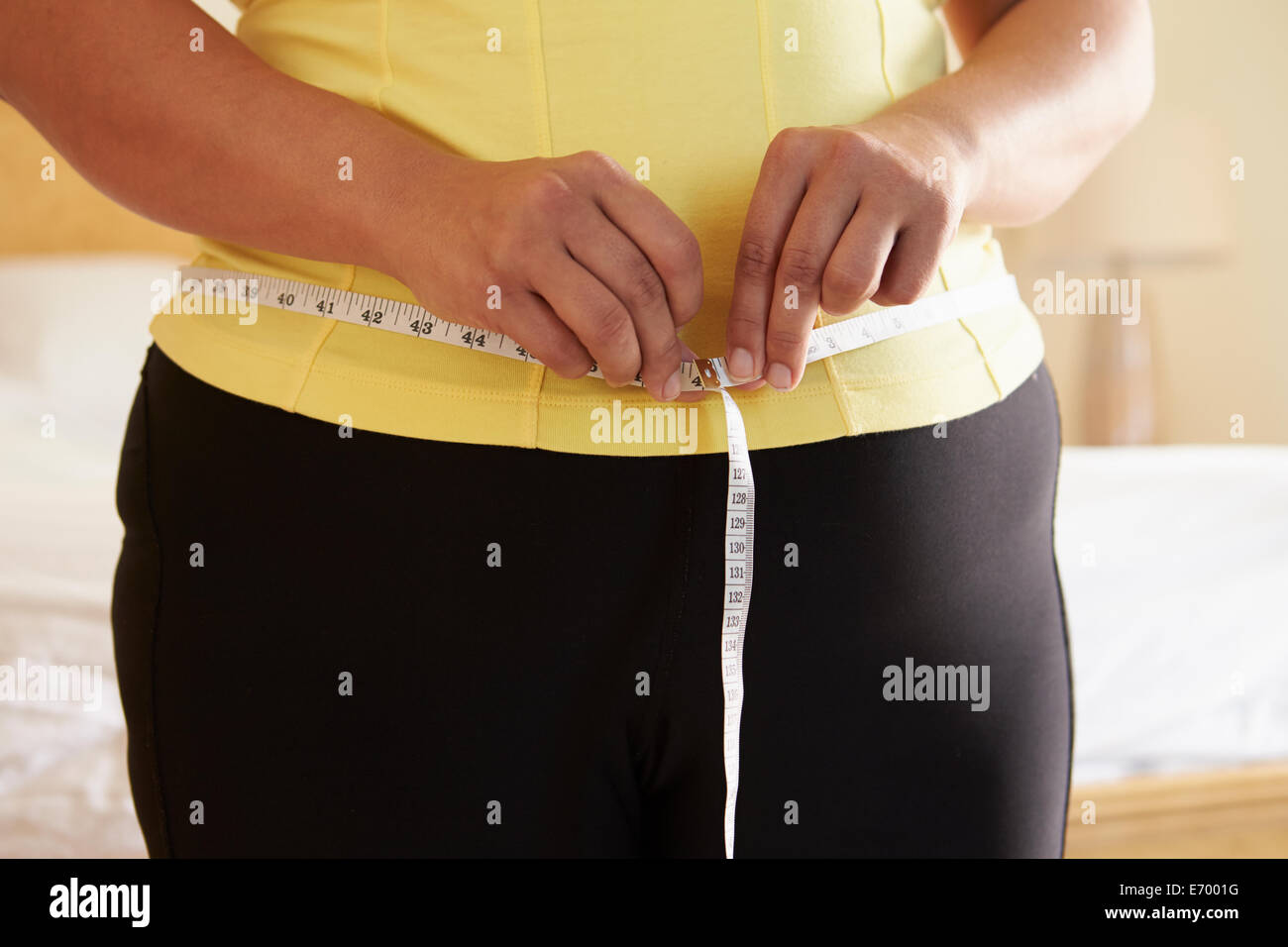 Cerca De Mujer con sobrepeso midiendo la cintura Foto de stock