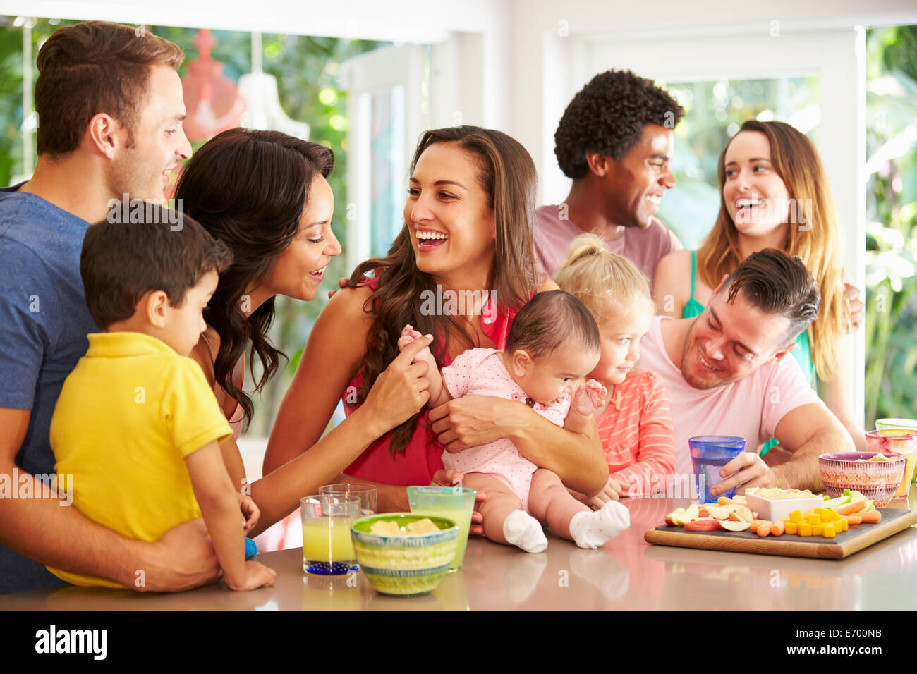 Grupo de familias disfrutando de aperitivos en casa Foto de stock