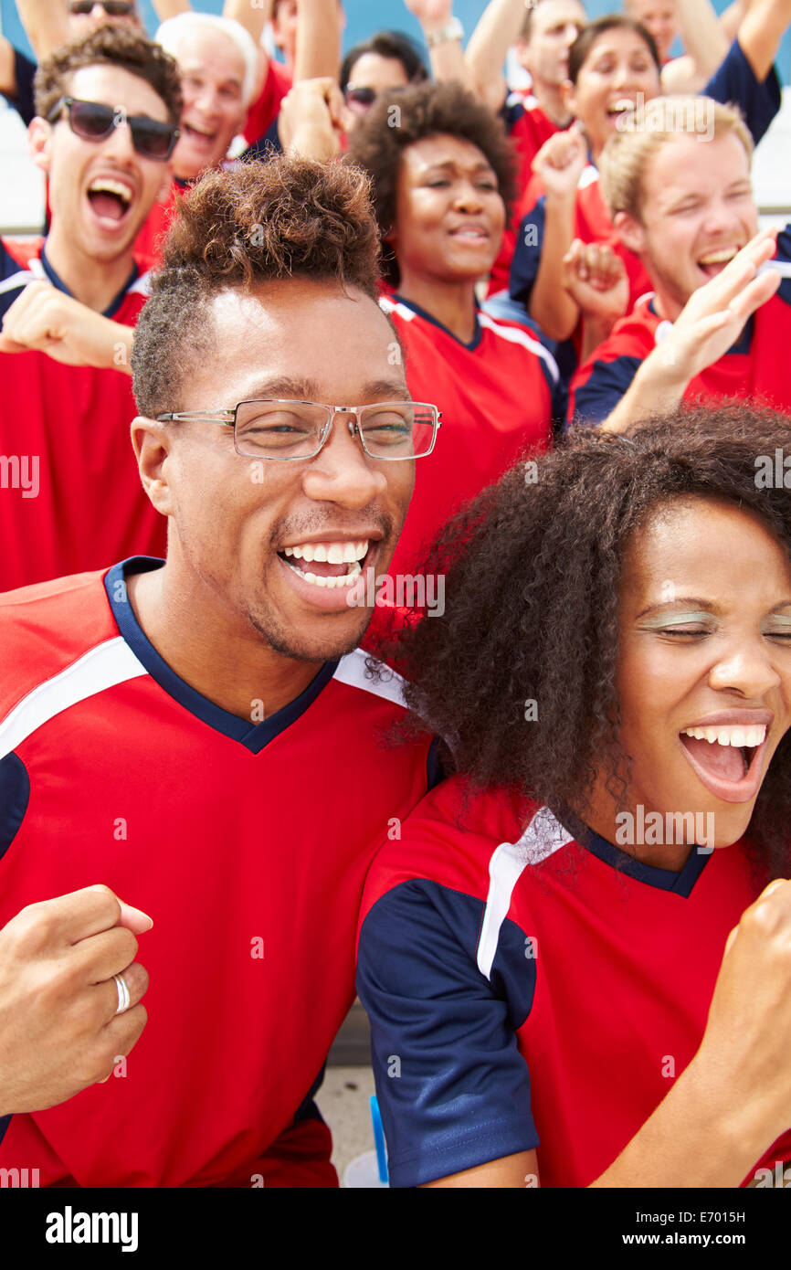 Los espectadores en los colores del equipo ver eventos deportivos Foto de stock