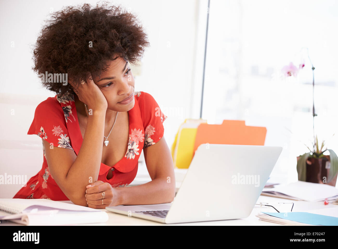 Frustrado Mujer trabajando en un escritorio en Design Studio Foto de stock