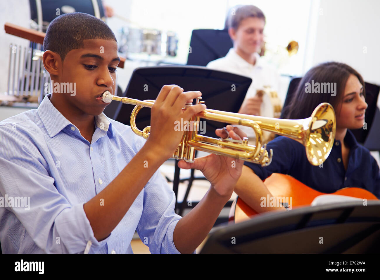 Alumno varón tocando la trompeta en la orquesta de la Escuela Secundaria Foto de stock