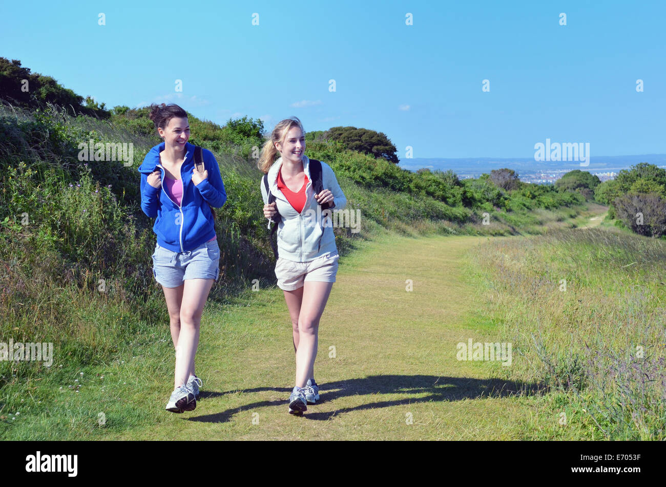 Dos jóvenes mujeres que caminan a lo largo de la ruta costera Foto de stock