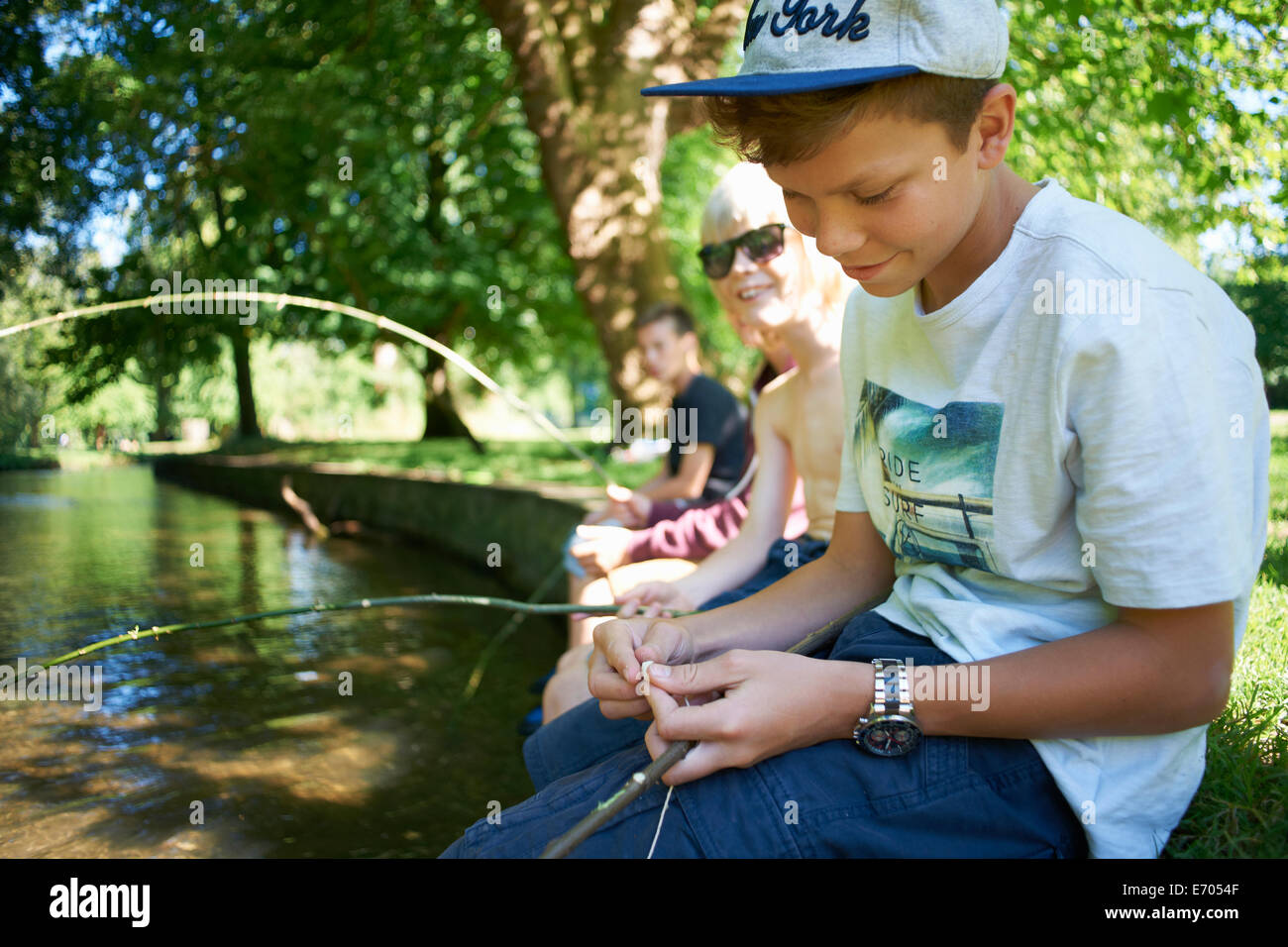 Los niños sosteniendo palos, pesca Foto de stock